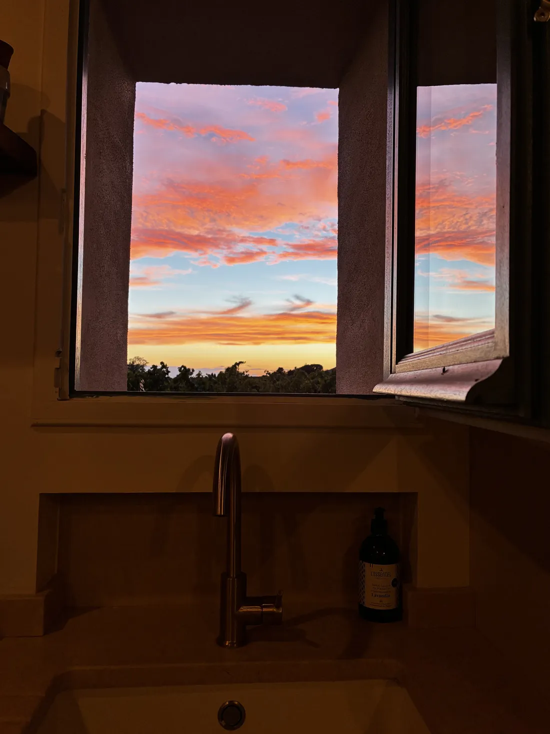 Coucher de soleil sur la campagne provençale vu depuis une fenêtre du mas