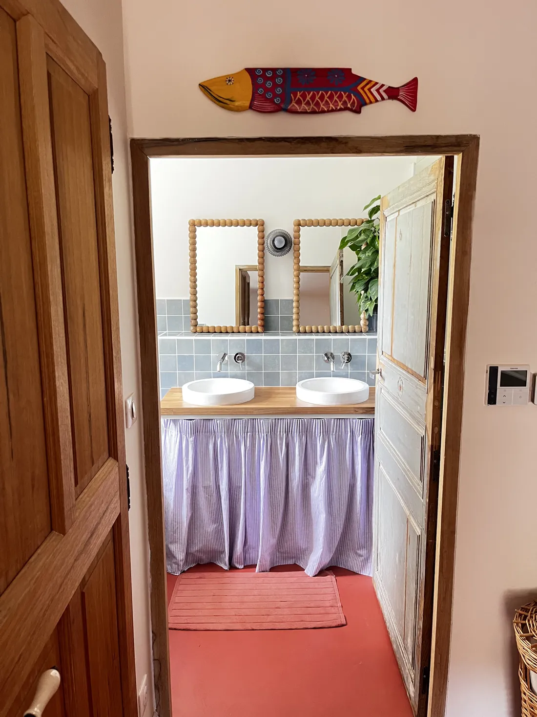 Salle de bain à double vasque, miroirs en bois et rideau de lin, mas rénové